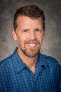 Portrait of Steve Longenecker posing against a neutral background