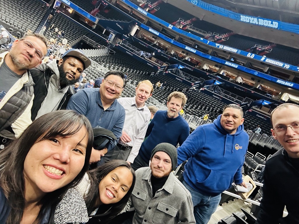group photo of diverse Community IT staff at a stadium for a social event